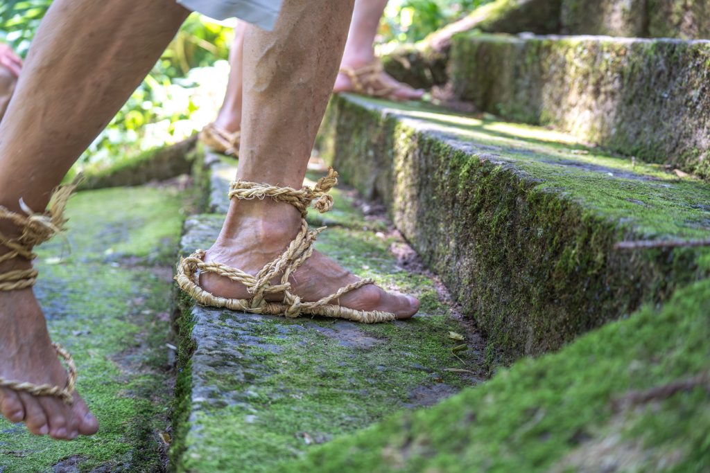 Traditional Japanese straw sandals walking up moss lined stairs for Kosuge festival in Nagano, Japan
